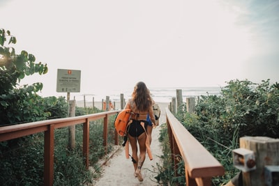 Dressed in a pink and black bikini ms orange surfboard
